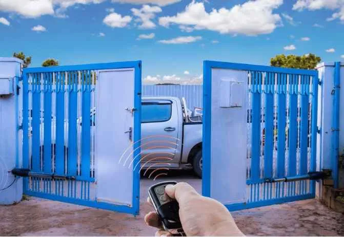 Automatic swing gate installed at a villa entrance in Oman, with the gate automation motor and articulated arm mounted on the pillar.